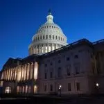Zgrada američkog Kongresa u Washingtonu snimljena u sumrak, osvijetljena iznutra i izvana, simbol američke zakonodavne vlasti.