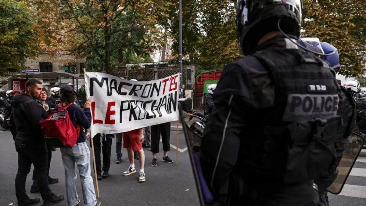 Policajci blokiraju prosvjednike s transparentom „Macron, ti si sljedeći” u Parizu.