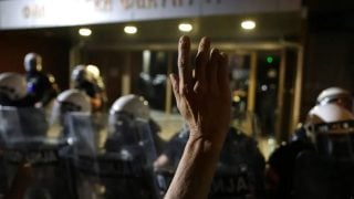 Prosvjednik podiže ruku ispred interventne policije tijekom prosvjeda protiv policijske brutalnosti u Novom Sadu, 5. rujna 2025.