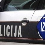 Policijsko vozilo u Bosni i Hercegovini s natpisom "Policija" i brojem za hitne pozive 122 na bočnoj strani auta.