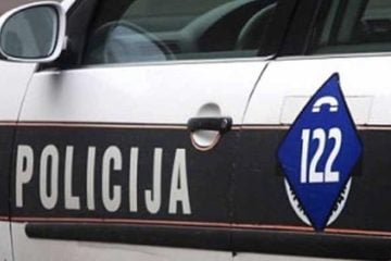 Policijsko vozilo u Bosni i Hercegovini s natpisom "Policija" i brojem za hitne pozive 122 na bočnoj strani auta.