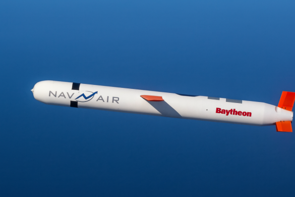 Projektil Tomahawk u letu iznad mora, u visokoj rezoluciji, s jasno vidljivim oznakama „NAV AIR“ i „Raytheon“ na trupu.