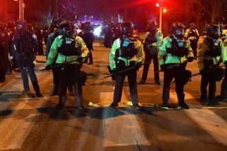 Državni policajci postrojavaju se na ulici u Minneapolisu nakon sukoba prosvjednika i saveznih snaga reda, 14. siječnja 2026.