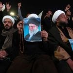 Šijitski klerici u Bagdadu drže plakate ajatolaha Alija Hameneija tijekom prosvjednog okupljanja na Trgu Tahrir.