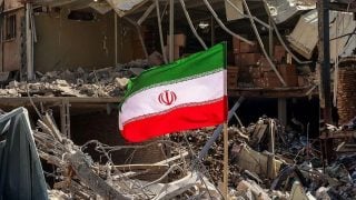 Iranska zastava među ruševinama uz uništenu stambenu zgradu u blizini trga Ferdowsi u Teheranu.