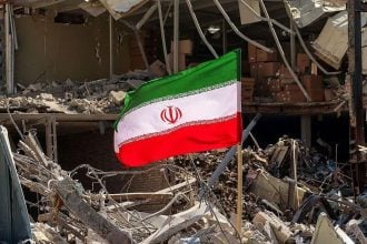 Iranska zastava među ruševinama uz uništenu stambenu zgradu u blizini trga Ferdowsi u Teheranu.