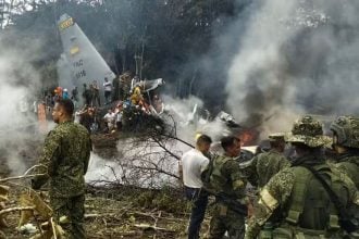 Vojnici i spasioci stoje pokraj zapaljenog vojnog zrakoplova Hercules nakon pada pri polijetanju u Puerto Leguizamu na jugu Kolumbije, 23. ožujka 2026.