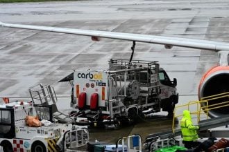 Radnik ukrcava prtljagu u zrakoplov EasyJeta dok cisterna za gorivo opslužuje avion u zračnoj luci Malpensa u Milanu.