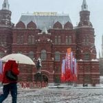 Osoba s kišobranom hoda ispred Kremlja tijekom snježne oluje u Moskvi.