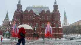 Osoba s kišobranom hoda ispred Kremlja tijekom snježne oluje u Moskvi.