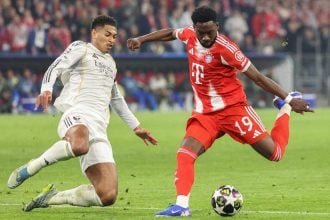 Alphonso Davies puca na gol dok Jude Bellingham ulazi u duel tijekom utakmice Bayerna i Real Madrida u Münchenu.
