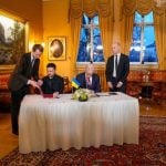 Volodimir Zelenski i Jonas Gahr Støre potpisuju dokumente tijekom sastanka u Oslu.