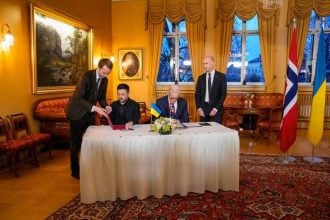 Volodimir Zelenski i Jonas Gahr Støre potpisuju dokumente tijekom sastanka u Oslu.